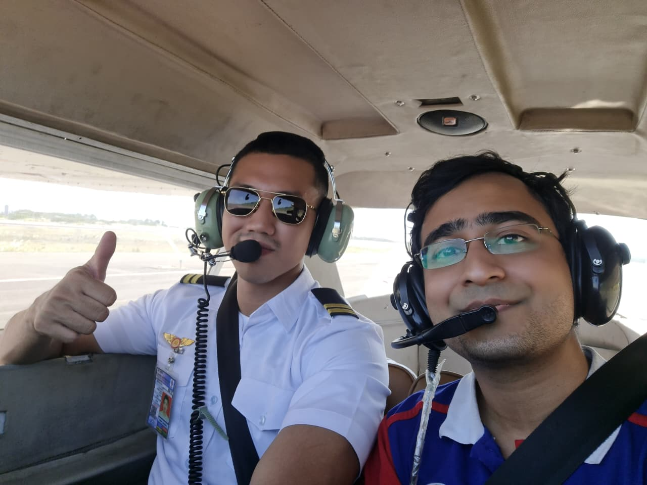 Instructor and student giving a thumbs up in the cockpit